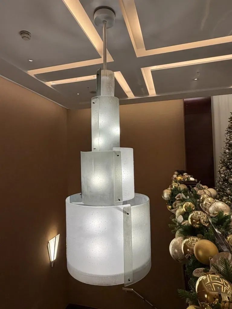 Three-tiered cylindrical glass pendant light in a foyer